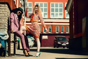 Stylish women posing in an urban alley showcasing contemporary fashion trends.